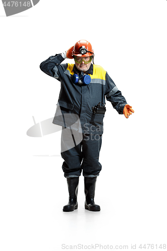 Image of The studio shot of senior bearded male miner standing at the camera on a white background.