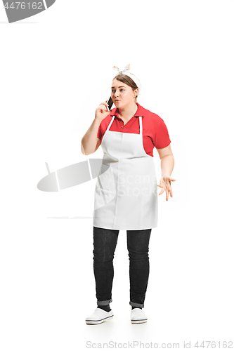 Image of Portrait of cute smiling woman with mobile phone in her hands in the studio, isolated on white background