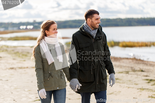 Image of couple walking along autumn beach