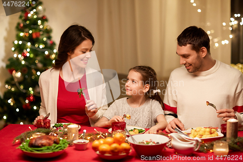 Image of happy family having christmas dinner at home