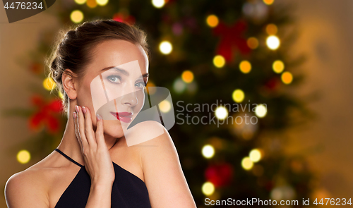 Image of beautiful woman over christmas tree lights