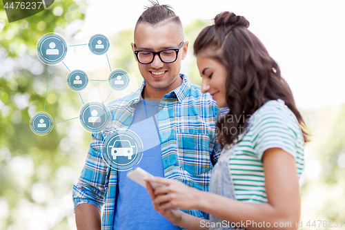 Image of happy couple using car sharing app on smartphone