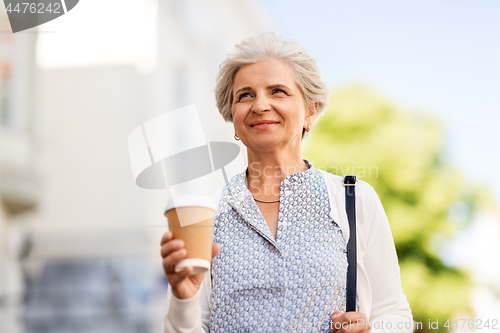 Image of senior woman drinking coffee at summer city