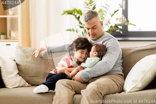 Image of happy father with preteen and baby son at home