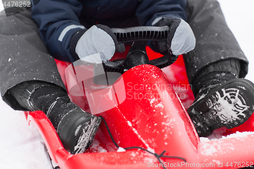 Image of close up of boy driving sled in winter