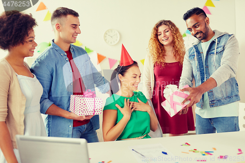 Image of team greeting colleague at office birthday party