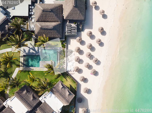 Image of Aerial view of amazing tropical white sandy beach with palm leaves umbrellas and turquoise sea, Mauritius.