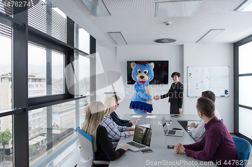 Image of boss dresed as bear having fun with business people in trendy of
