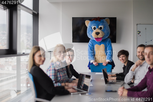 Image of boss dresed as bear having fun with business people in trendy of