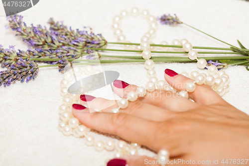 Image of Hands of a woman with red nail polish posed by an esthetician