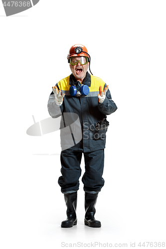 Image of The studio shot of senior bearded male miner standing at the camera on a white background.