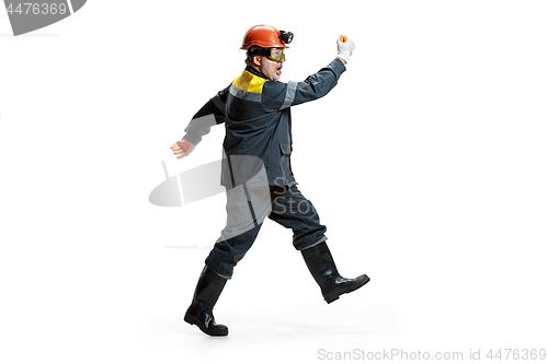 Image of The studio shot of senior bearded male miner standing at the camera on a white background.