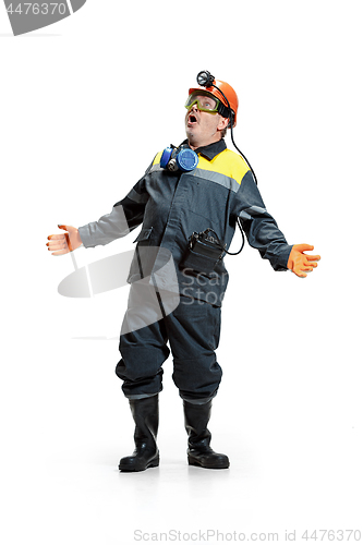 Image of The studio shot of senior bearded male miner standing at the camera on a white background.