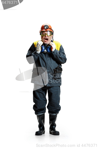 Image of The studio shot of senior bearded male miner standing at the camera on a white background.