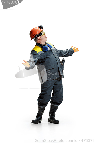 Image of The studio shot of senior bearded male miner standing at the camera on a white background.