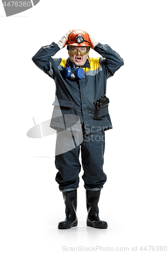 Image of The studio shot of senior bearded male miner standing at the camera on a white background.