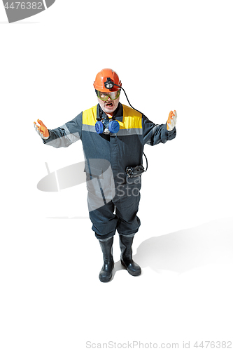 Image of The studio shot of senior bearded male miner standing at the camera on a white background.