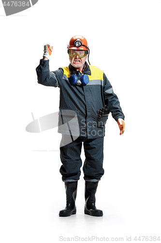 Image of The studio shot of senior bearded male miner standing at the camera on a white background.