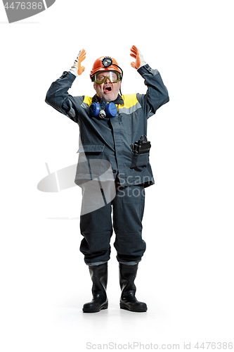 Image of The studio shot of senior bearded male miner standing at the camera on a white background.