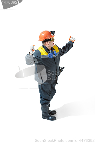 Image of The studio shot of senior bearded male miner standing at the camera on a white background.