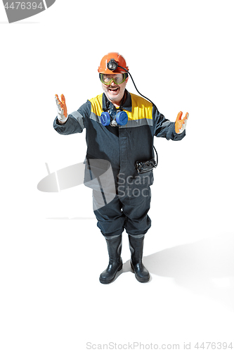 Image of The studio shot of senior bearded male miner standing at the camera on a white background.