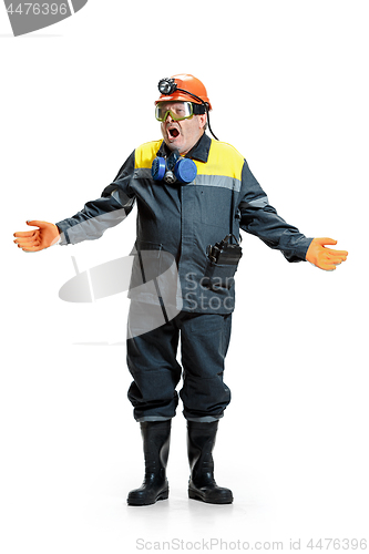 Image of The studio shot of senior bearded male miner standing at the camera on a white background.