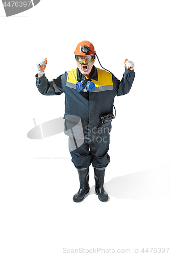 Image of The studio shot of senior bearded male miner standing at the camera on a white background.