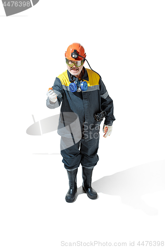 Image of The studio shot of senior bearded male miner standing at the camera on a white background.