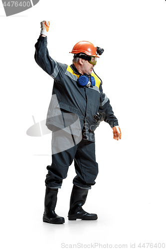 Image of The studio shot of senior bearded male miner standing at the camera on a white background.