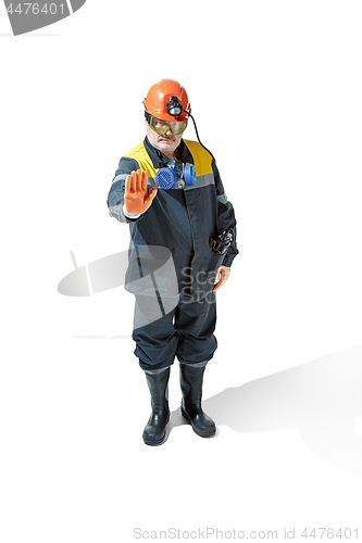 Image of The studio shot of senior bearded male miner standing at the camera on a white background.