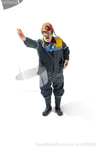 Image of The studio shot of senior bearded male miner standing at the camera on a white background.