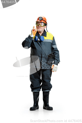 Image of The studio shot of senior bearded male miner standing at the camera on a white background.