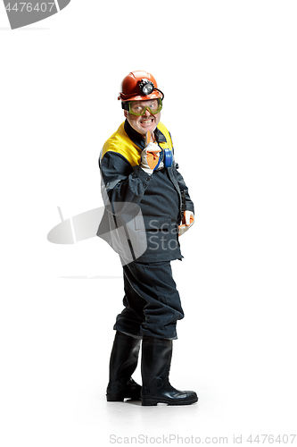 Image of The studio shot of senior bearded male miner standing at the camera on a white background.