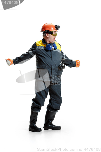 Image of The studio shot of senior bearded male miner standing at the camera on a white background.