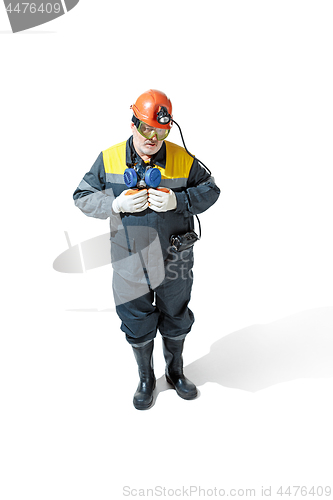 Image of The studio shot of senior bearded male miner standing at the camera on a white background.