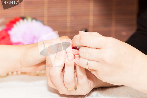 Image of Laying nail polish on a woman\'s hands