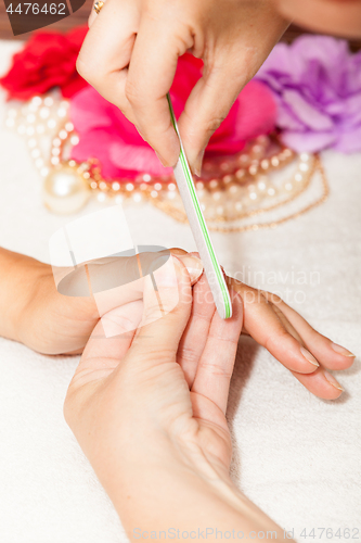 Image of The beautician polish the client\'s nails before putting nail polish