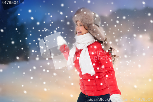 Image of happy woman in winter fur hat having fun outdoors