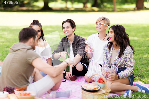 Image of happy friends with drinks at summer picnic