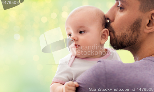 Image of close up of father kissing little baby daughter