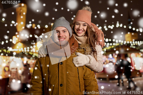 Image of happy couple hugging at christmas market