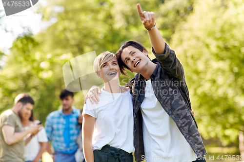 Image of happy teenage couple hugging at summer park