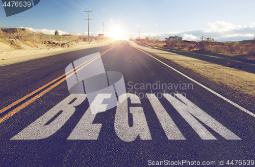 Image of close up of word begin on suburban asphalt road