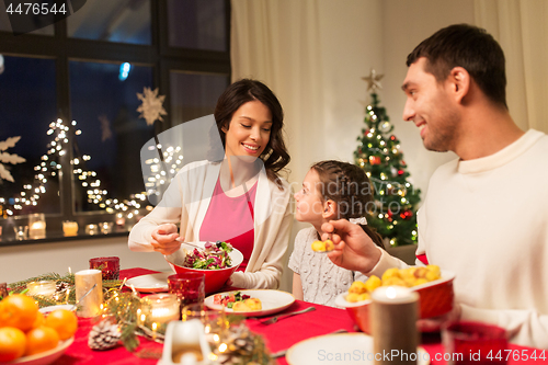 Image of happy family having christmas dinner at home