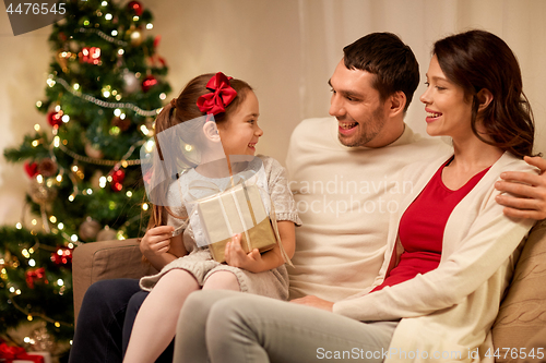 Image of happy family with christmas present at home