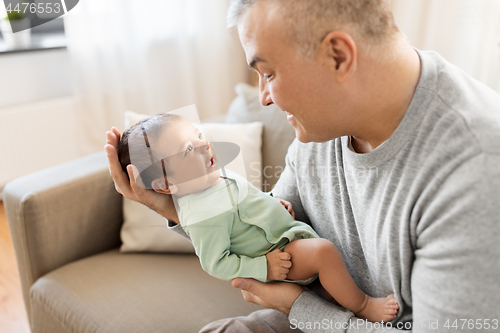 Image of happy father with little baby boy at home