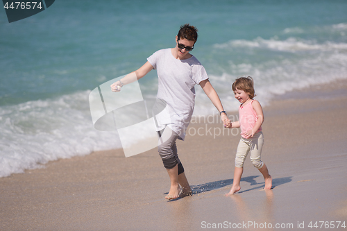 Image of mother and daughter running on the beach