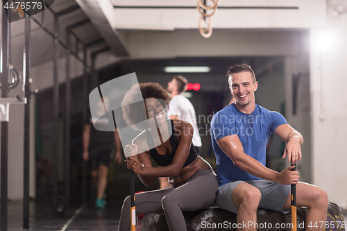 Image of multiethnic couple after workout with hammer