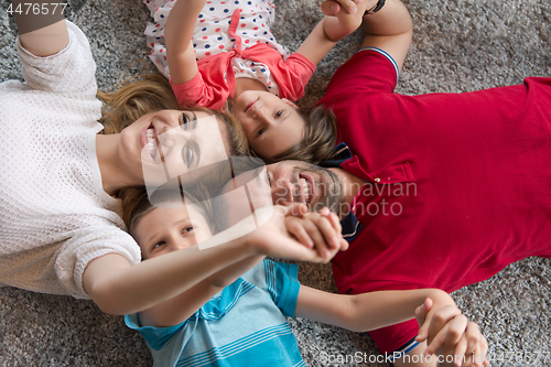 Image of happy family lying on the floor