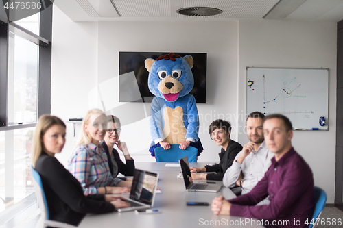 Image of boss dresed as bear having fun with business people in trendy of